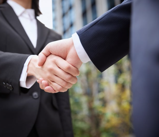 Poignée de main entre deux professionnels illustrant le développement du réseau professionnel et les opportunités de carrière.